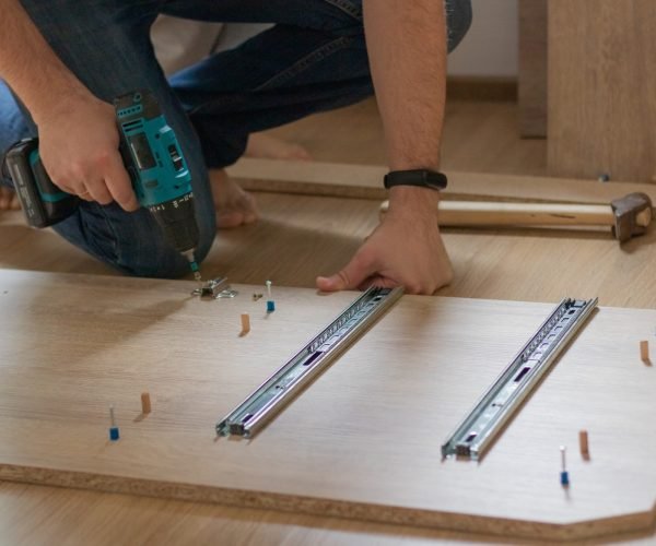 A man is assembling a closet for a children’s room. Furniture assembly. A man is assembling a closet for a children's room. Furniture assembly.