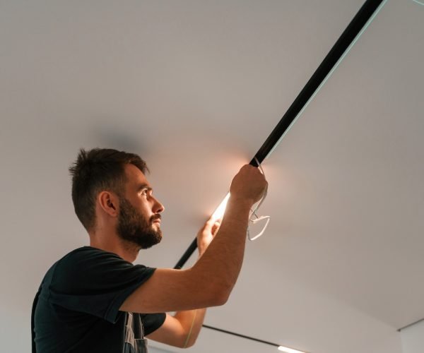 Man is working with lighting equipment indoors at domestic room Man is working with lighting equipment indoors at domestic room