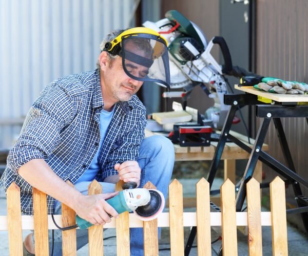 portrait of a handyman making a fence