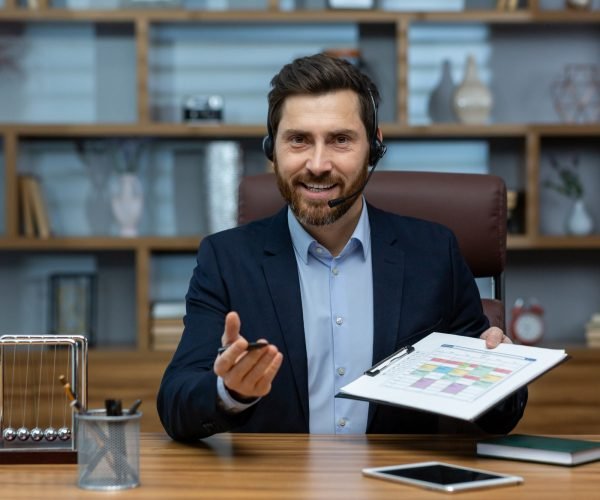 Professional businessman with headset presenting schedule in a cluttered home office environment